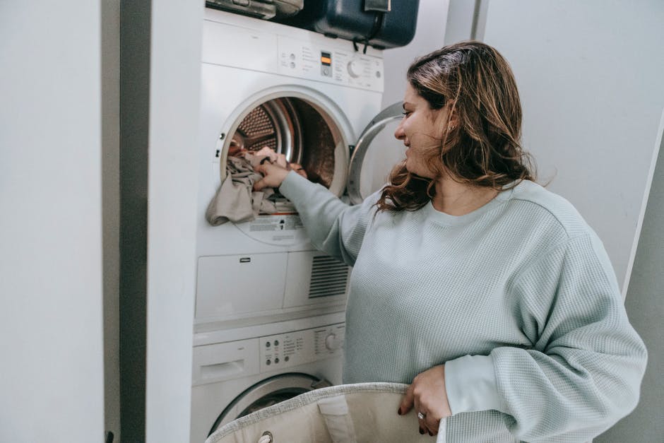 Positive woman loading washing machine
